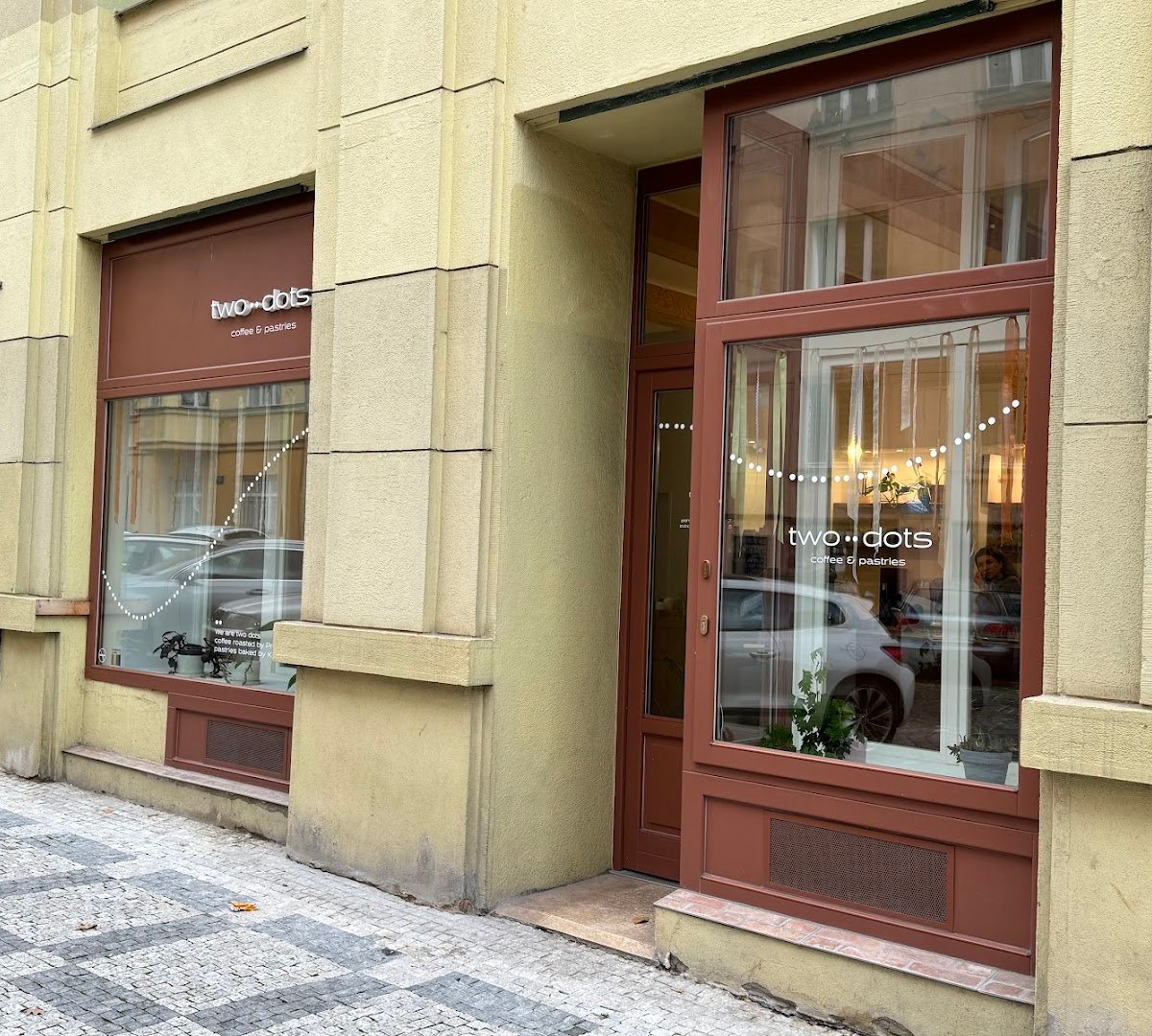 Storefront of two dots coffee & pastries, specialty coffee shop in Prague