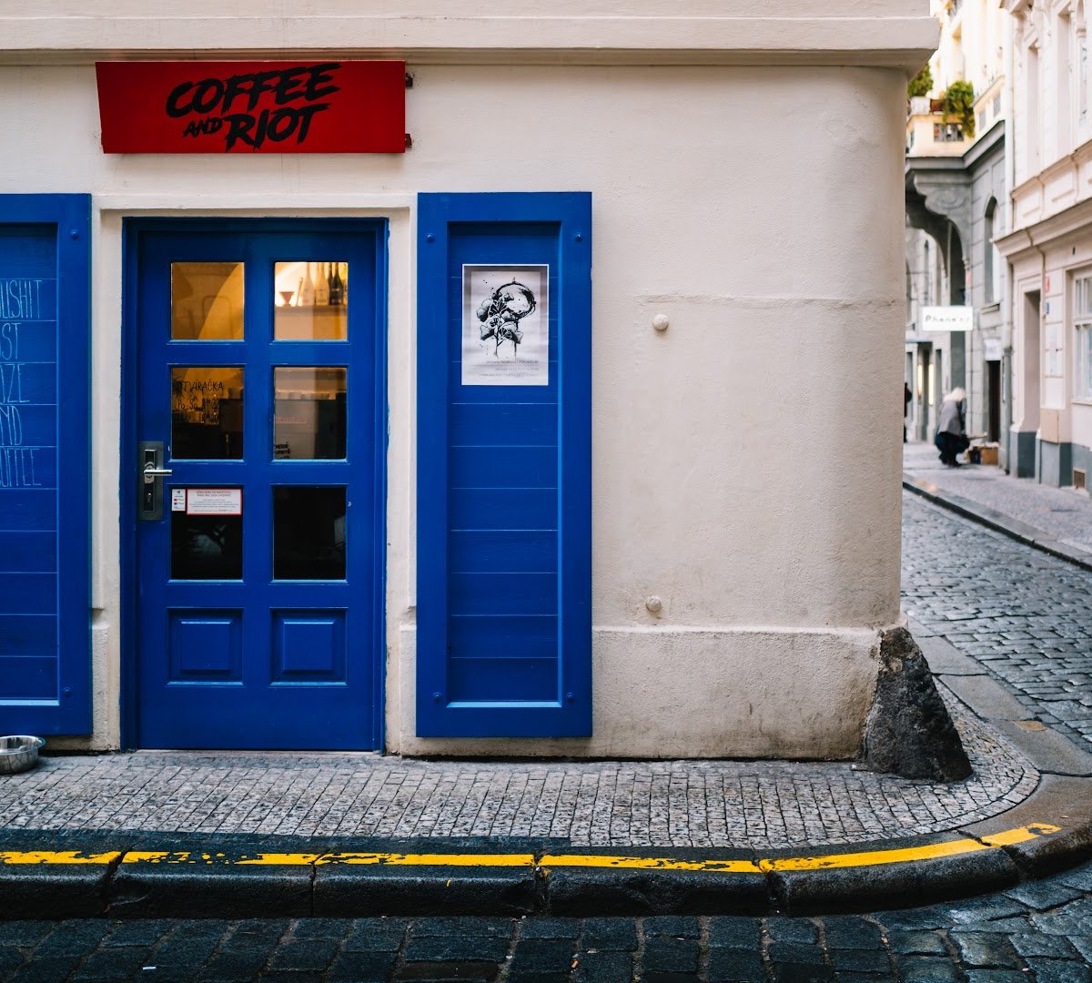 Storefront of Coffee and Riot, specialty coffee shop in Prague